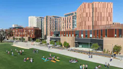 Aerial view of new mixed-use student residence hall and classroom buildings above lawn space.